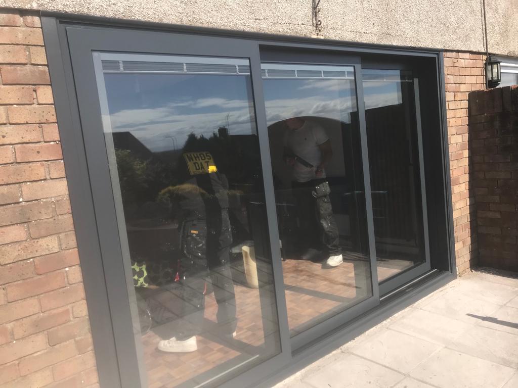 Dark grey sliding patio doors with three glass panels