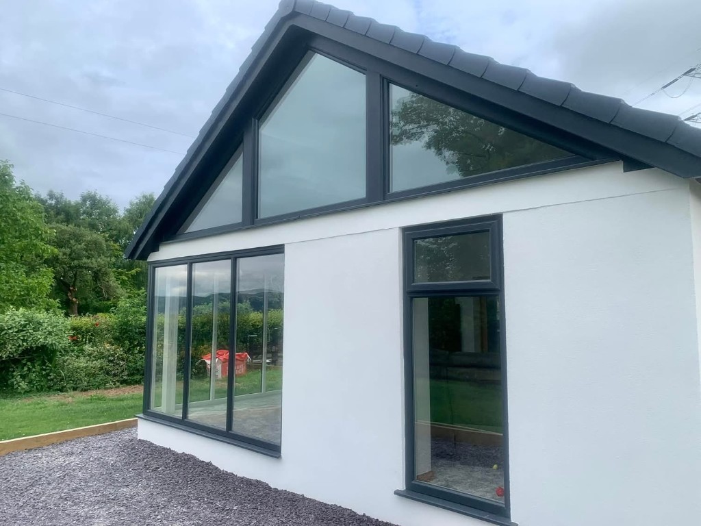 Modern extension with triangular gable windows and bifold doors