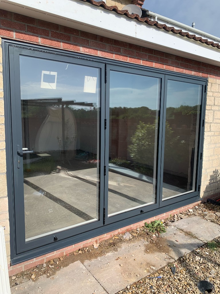 Dark grey bifold doors with three glass panels
