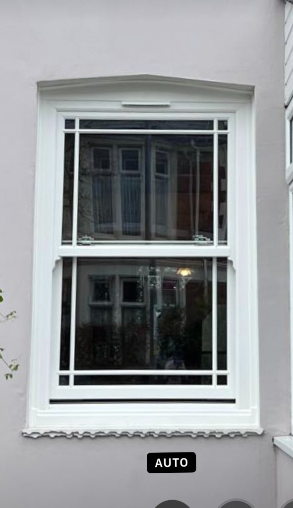 White uPVC sliding sash window with glazing bars and scalloped sill